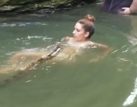 Virales Video „Junge furchtlose Frau geht mit ihrer Schlange (Haustier, Boa Constrictor) eine Runde im See schwimmen“